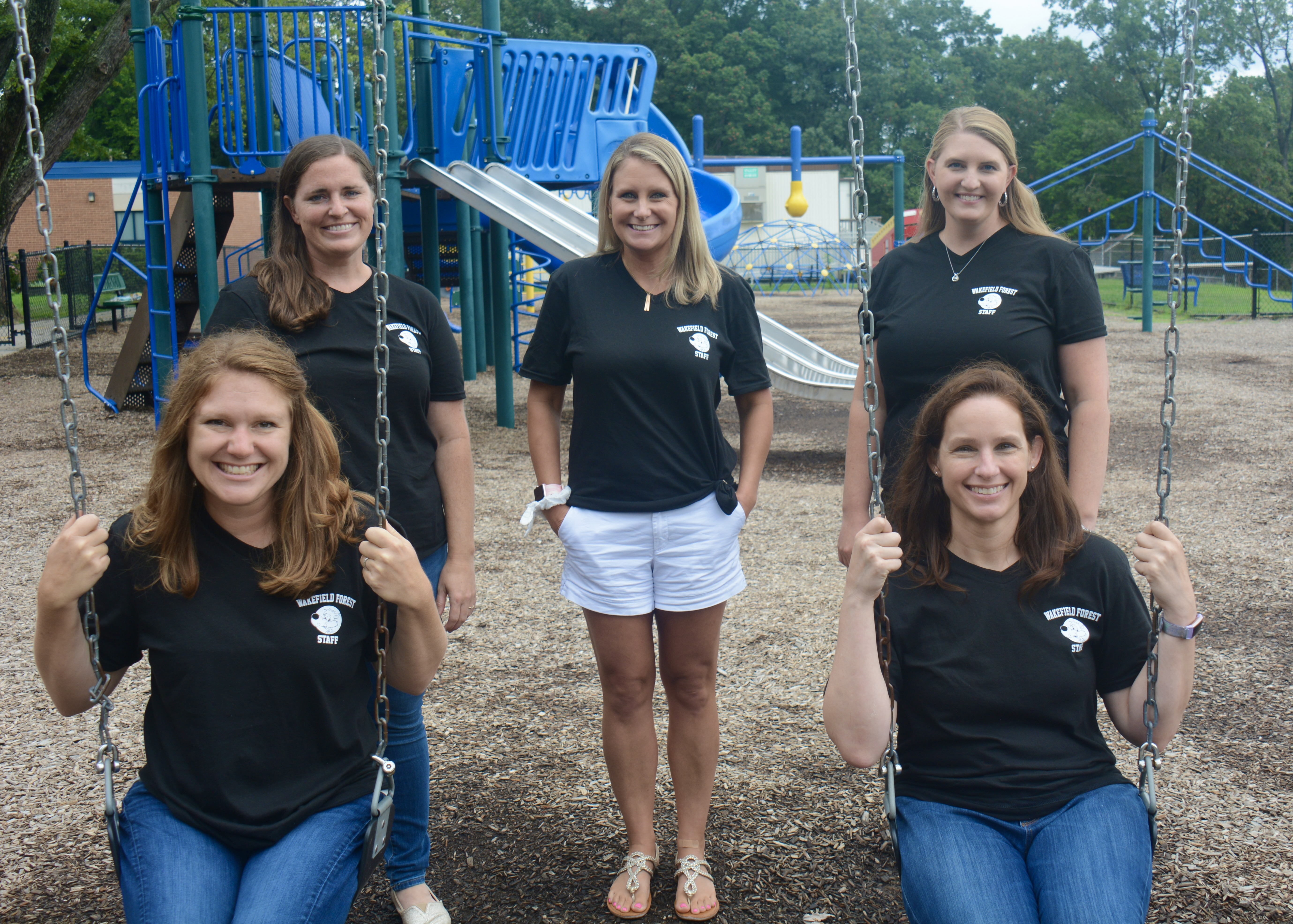 Picture of the first grade team sitting on playground equipment