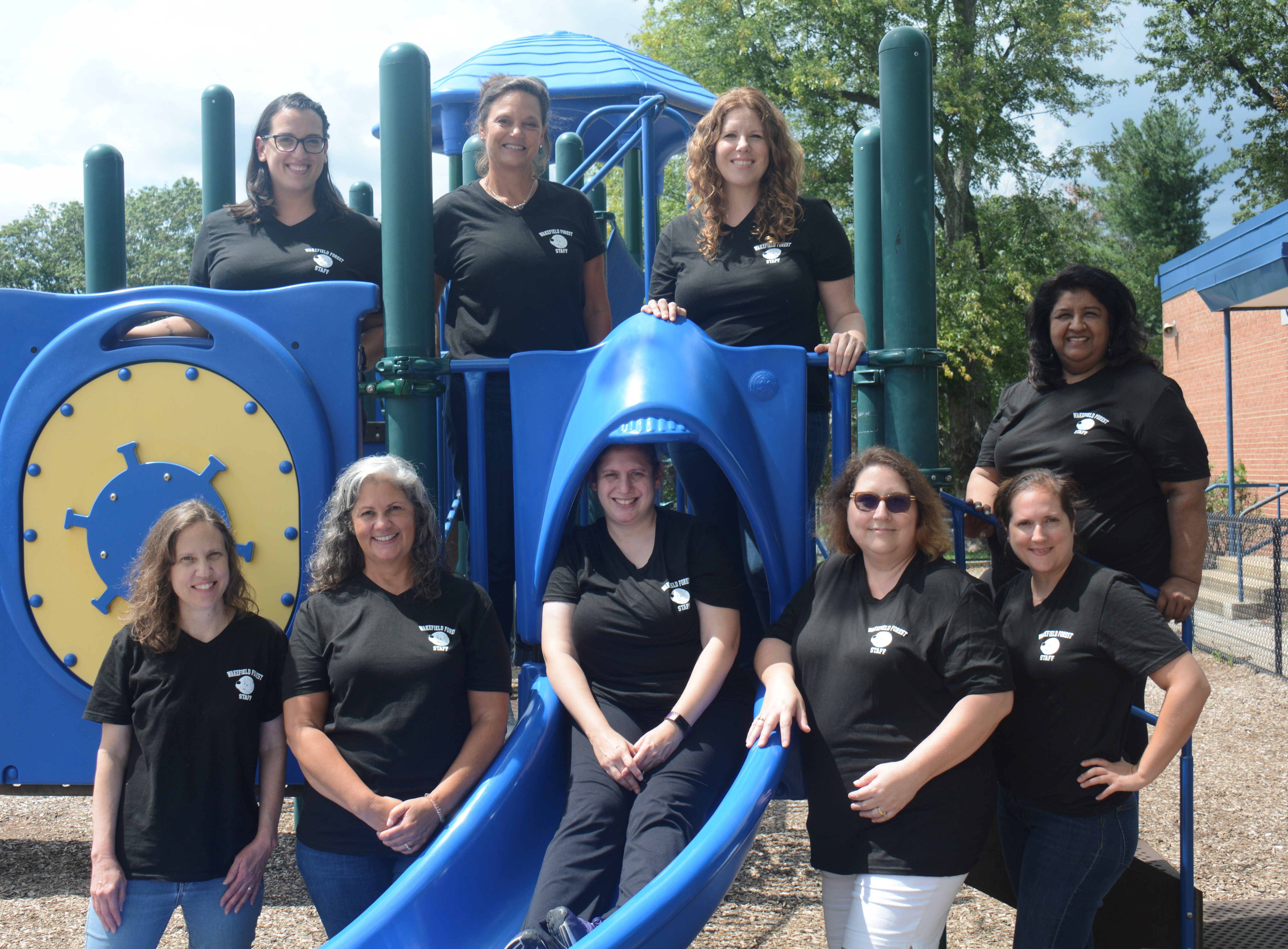 Picture of the kindergarten teachers outside on playground equipment